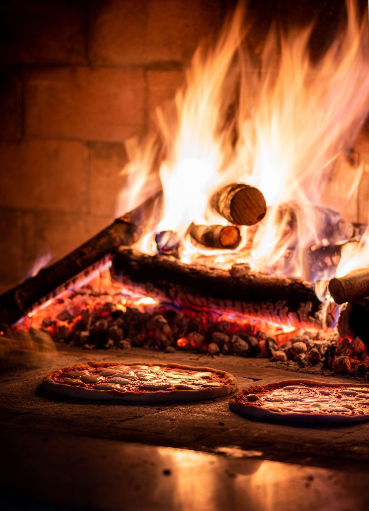 Forno tradicional a lenha com duas pizzas a assar